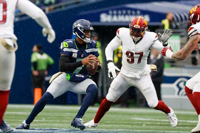 Seattle Seahawks quarterback Geno Smith (7) looks to pass against Washington Commanders defensive end Efe Obada (97) during the first quarter at Lumen Field.